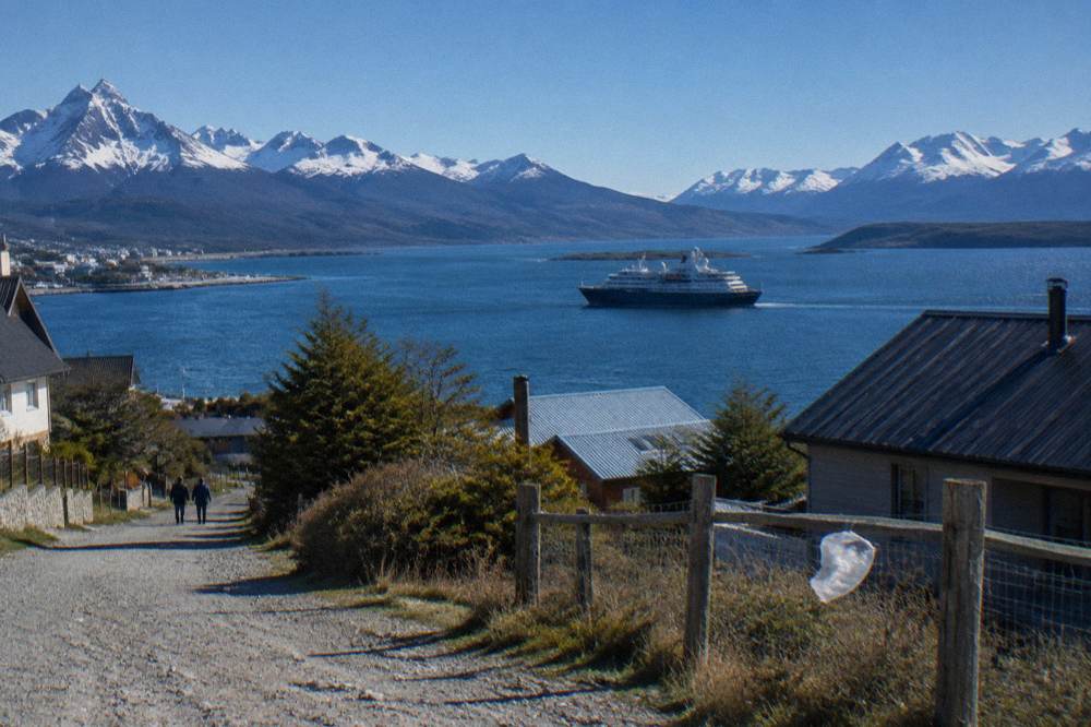 An expedition ship departing Ushuaia across the Beagle Channel toward open water