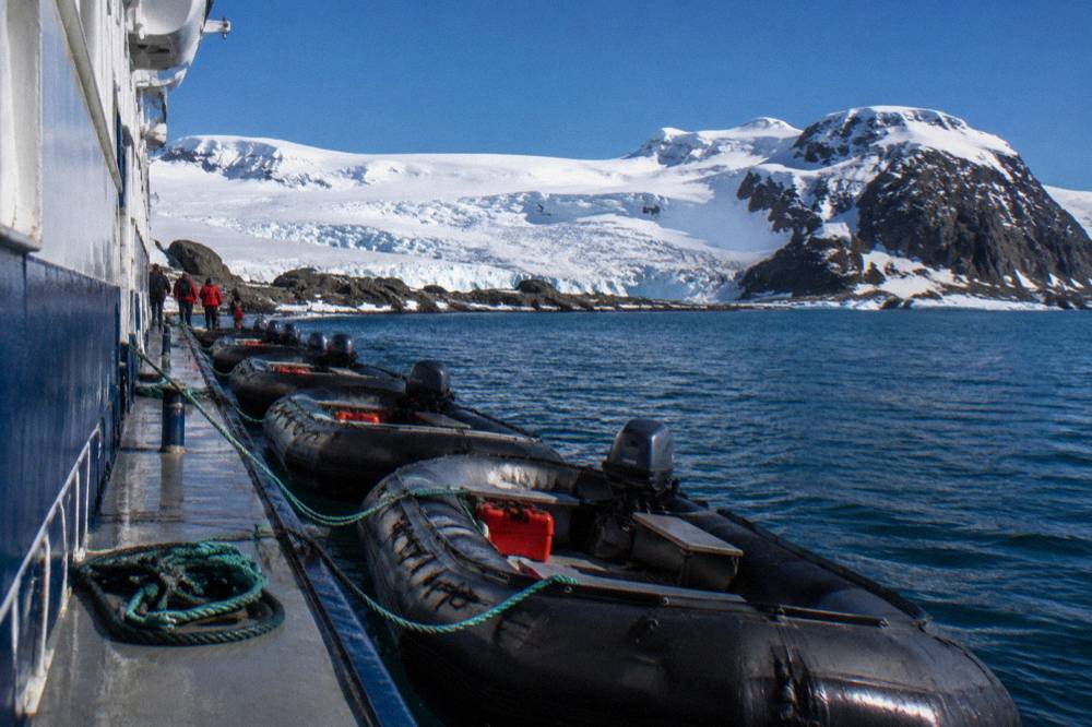 A row of Zodiacs tied alongside an expedition ship after a landing