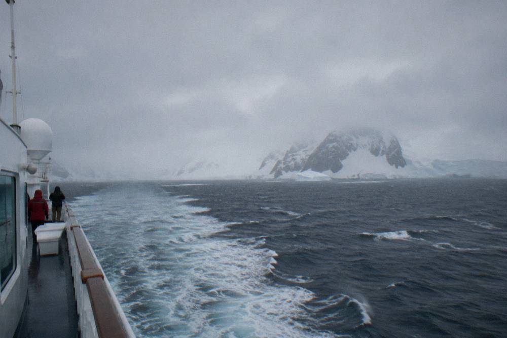 An expedition ship cutting through open grey water on a long Drake Passage crossing.