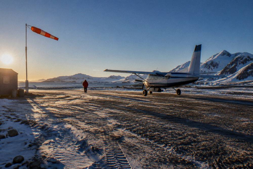 A small charter aircraft on a gravel runway on King George Island