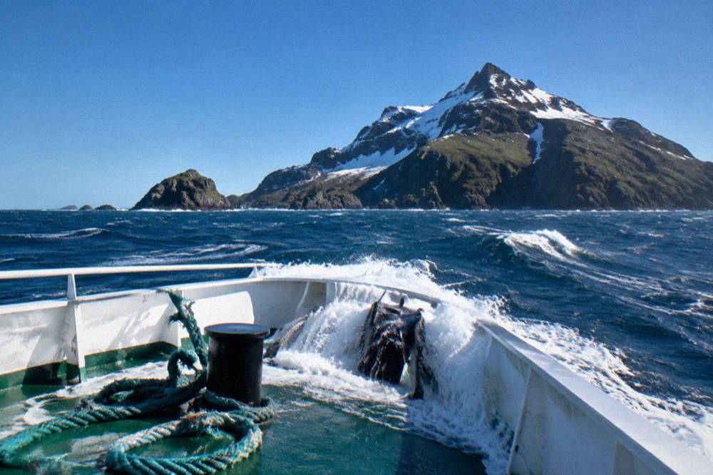 Expedition ship bow cutting through a moderate swell at sea