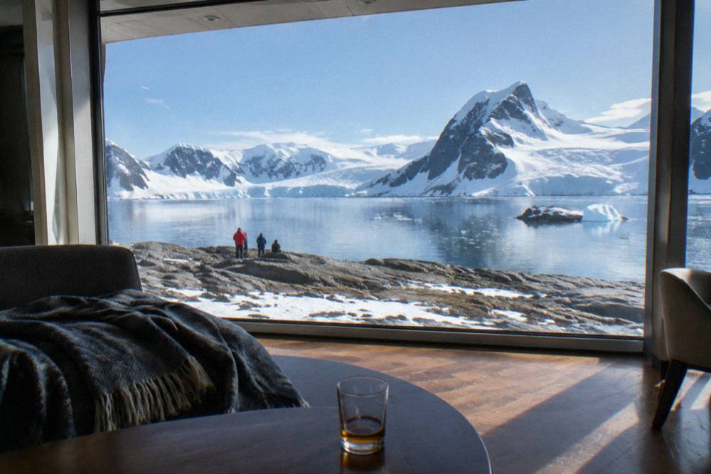 Elegant ship lounge with panoramic windows over calm polar water