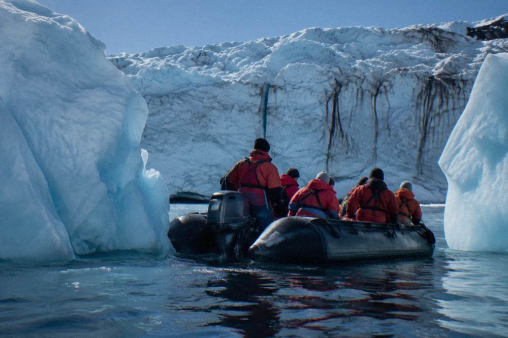 Zodiac cruising between icebergs near the Antarctic shoreline