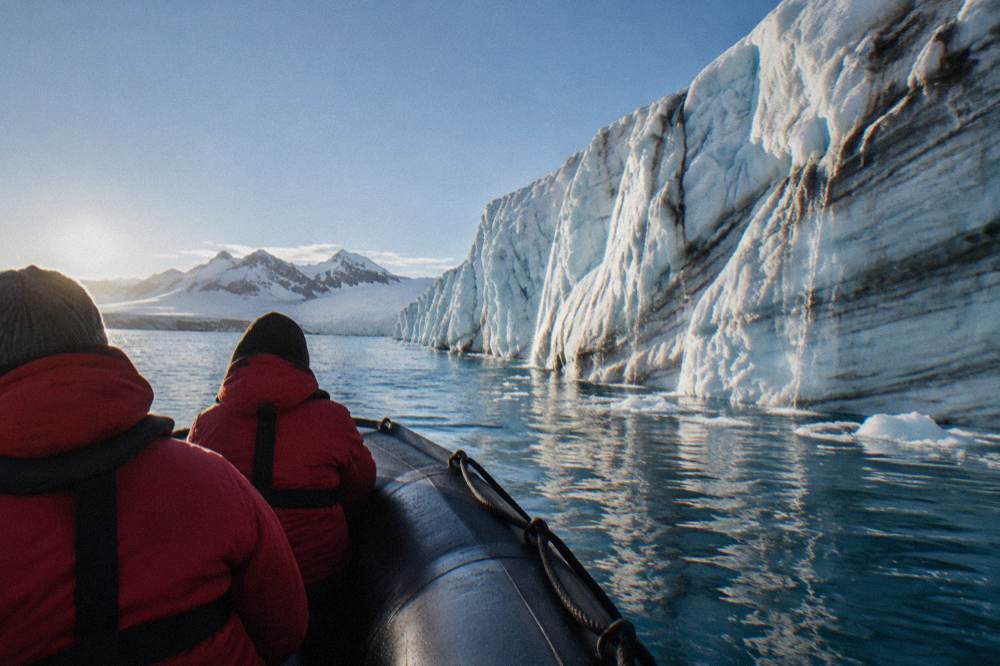 Zodiac cruising past a glacier face in the Antarctic Peninsula
