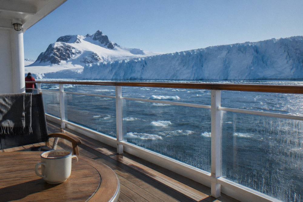 Expedition ship suite balcony overlooking calm polar water