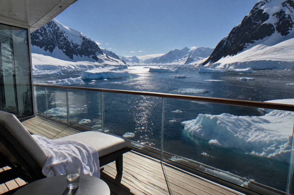 Elegant suite balcony overlooking icebergs and dark polar water